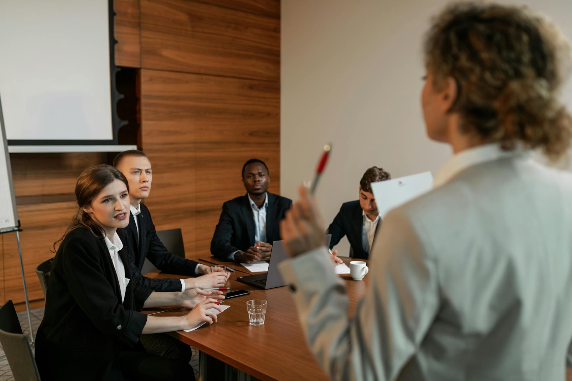 woman in beige business suit holding red and silver ballpen